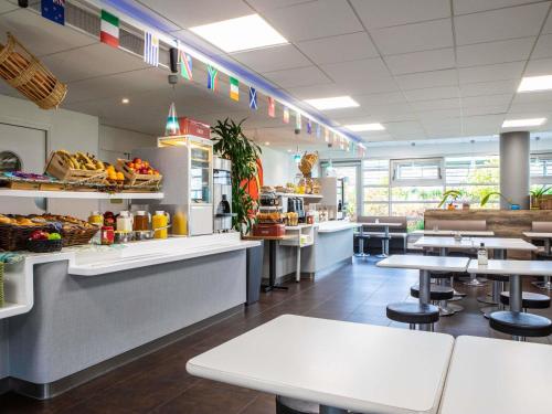 a fast food restaurant with tables and a counter at ibis budget Roissy CDG Paris Nord 2 in Roissy-en-France