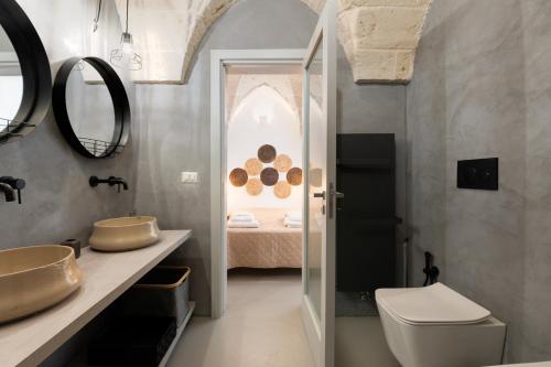 a bathroom with a sink and a toilet and a bedroom at Gente di Mare Luxury Home in Fasano