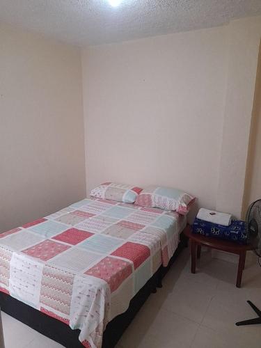 a bedroom with a bed and a table in it at Alojamiento Central Ibagué in Ibagué
