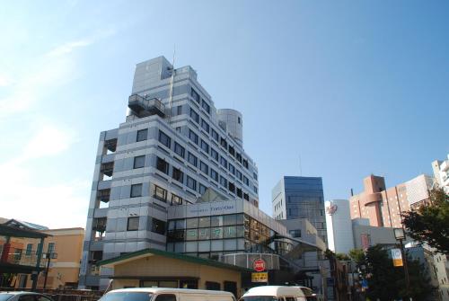 a tall building with cars parked in front of it at Town Hotel 41 in Kanazawa