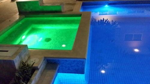 a large swimming pool with blue lights in a building at Puerta diamante acapulco in Acapulco