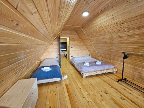 a room with two beds in a log cabin at Brvnara Tarin osmeh - u srcu Nacionalnog parka Tara in Sekulić 
