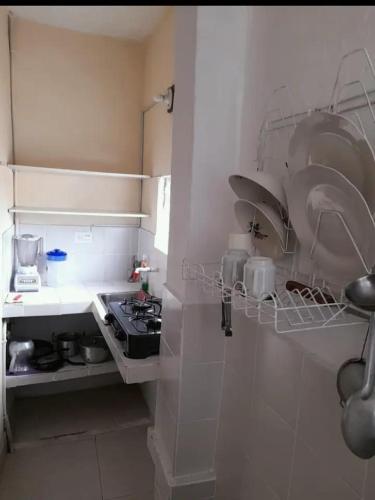 a white kitchen with a stove and some dishes at Alojamiento Central Ibagué in Ibagué