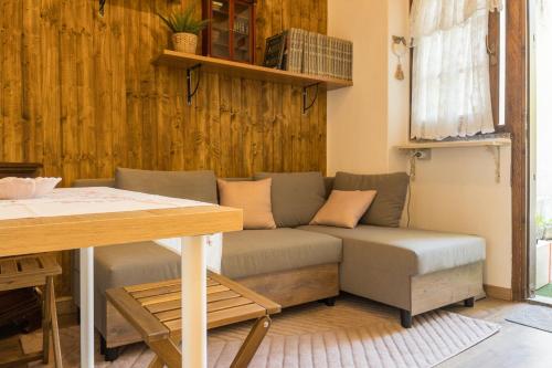 a couch in a living room with a table at Dolce Barzio - appartamento in centro in Barzio