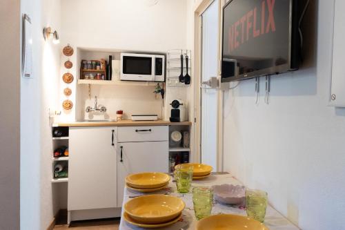 a small kitchen with a table with yellow plates on it at Dolce Barzio - appartamento in centro in Barzio