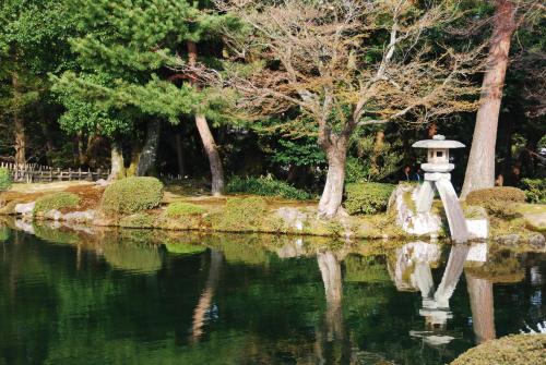 a garden with a fountain in the middle of a pond at Town Hotel 41 in Kanazawa