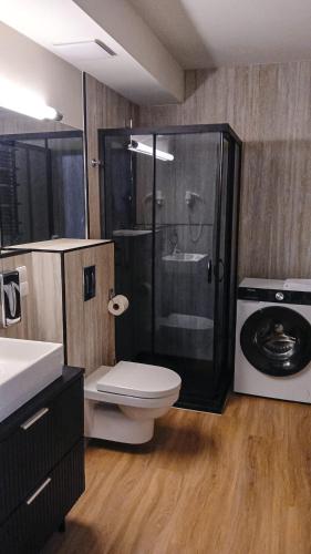 a bathroom with a shower and a toilet and a sink at Royal VIP in Kołobrzeg