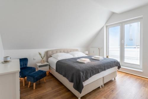 ein weißes Schlafzimmer mit einem Bett und einem Fenster in der Unterkunft 2 Schlafzimmer, Offene Küche, Balkon und Terrasse - moderne 90qm in ruhiger, zentraler Lage - nur 500m bis zum Strand in Warnemünde