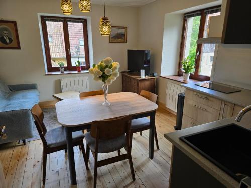 a kitchen with a table with a vase of flowers on it at Echappée Verte in Breitenbach-Haut-Rhin
