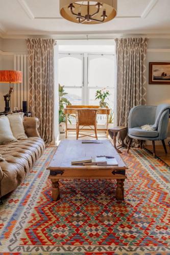a living room with a couch and a coffee table at Ty'n Porth - By Rowes Retreats in Falmouth