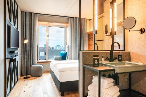 a hotel room with a sink and a bed at Me and All Hotel Kiel, by Hyatt in Kiel