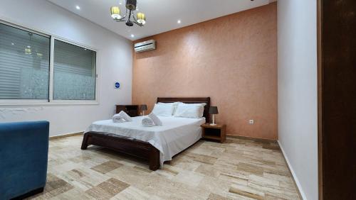 a bedroom with a bed and a chair and a window at Family fun farm - Évasion Nature - piscine et ferme in Berrechid