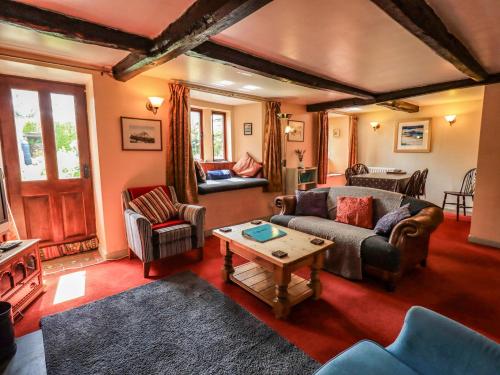 a living room with couches and a table at Tethera Cottage in Penrith