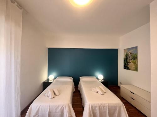 two beds in a room with a blue wall at Mareluce in Letojanni