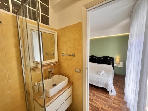 a bathroom with a tub and a sink and a bed at Mareluce in Letojanni