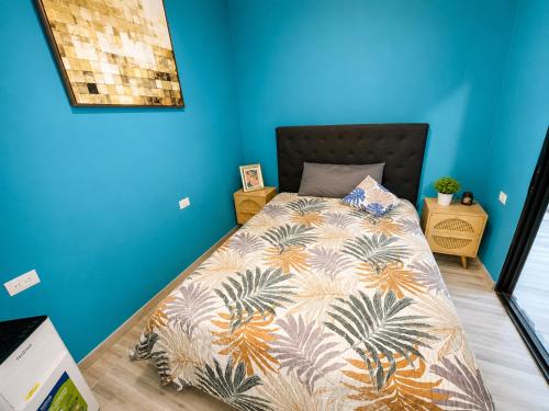 a bedroom with a bed with a blue wall at Jungle Serenity Haven in Cocles