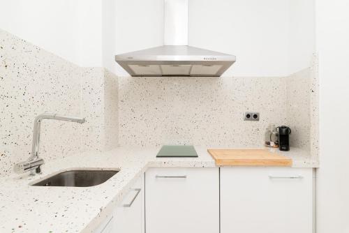 a white kitchen with a sink and a stove at Casa 2 Hab con Terraza & Barbacoa en Ubicación Céntrica in Gandía