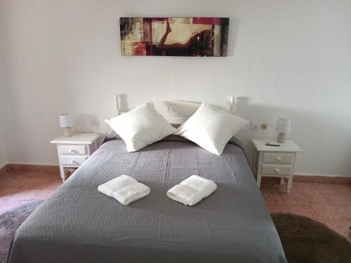 a bedroom with a bed with two white towels on it at Casa Lara - Sierra de Cazorla in Quesada
