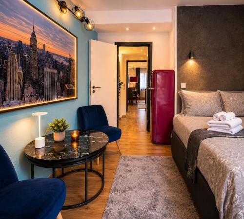 a room with a bed and a table and a red refrigerator at Bellevue Residence l City Balkon in Koblenz