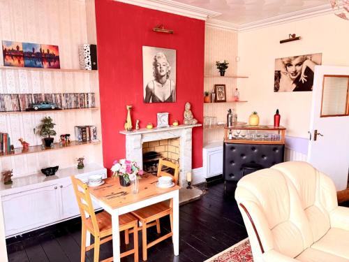 a living room with a table and a fireplace at Ramsgate Corner Retreat in Ramsgate
