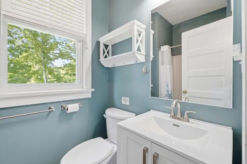 a bathroom with a toilet and a sink and a window at The Jackrabbit - 3 Summer Village in Cherry Valley