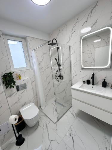 a white bathroom with a shower and a toilet at Apartament Bucovina Bellevue in Gura Humorului