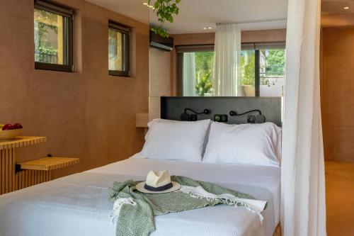 a bedroom with a bed with a hat on it at Nest In The Yard in Parga