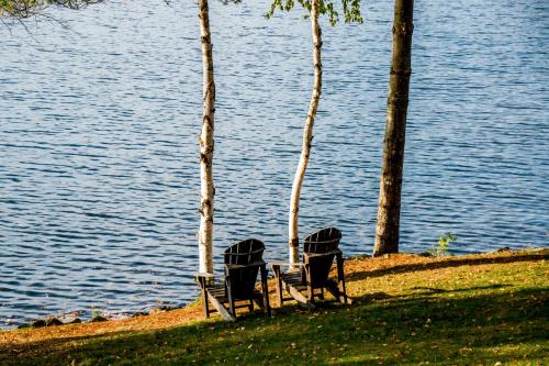 two chairs sitting next to a body of water at The Woods Inn in Inlet