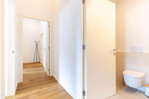 a bathroom with a toilet and a hallway at ASTRO Emanuelle E by LovelyStay in Leça da Palmeira