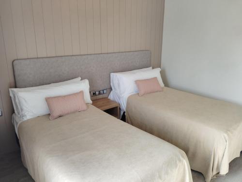 two beds sitting next to each other in a room at Hotel Vélez in Vélez-Rubio