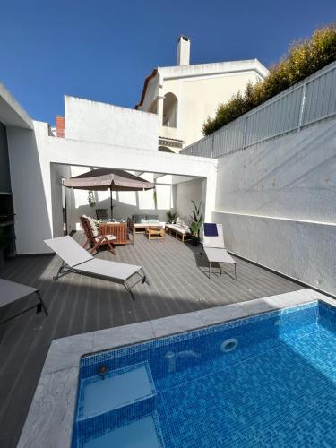 a house with a swimming pool and a patio at Valadares Pool Villa in Corroios