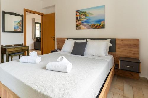 a bedroom with a bed with two towels on it at Helen's 11 boutique in Achladies
