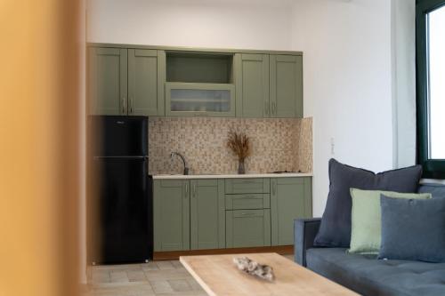 a kitchen with green cabinets and a refrigerator and a couch at Helen's 11 boutique in Achladies