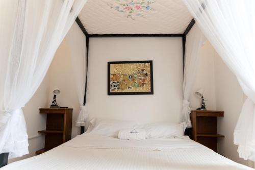 a bedroom with a white bed with white curtains at Pugliaholidayplus - IL VILLONE NEL BOSCO in Polignano a Mare