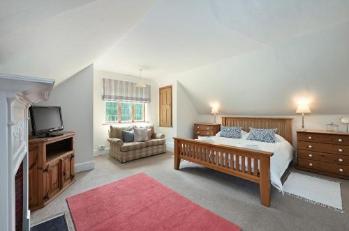 a bedroom with a bed and a tv and a couch at Hockley House by Bloom Stays in Folkestone