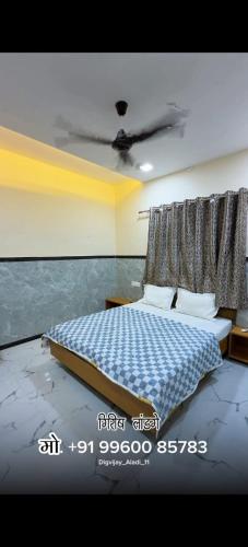 a bedroom with a bed with a blue and white blanket at Sai Samarth Residency Akkalkot in Akalkot