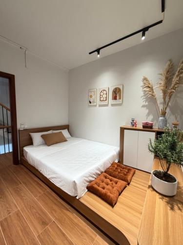 a bedroom with a large bed with a wooden floor at Gasu home in Ninh Binh