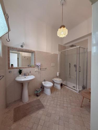 a bathroom with two toilets and a shower and a sink at Appartamento familiare in centro a due passi dai trulli - Casa Costanza in Alberobello