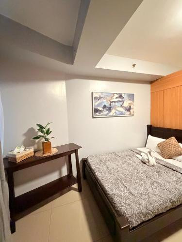 a bedroom with a bed and a table with a plant at Shell Residences Staycation MOA & NAIA by Keith in Manila