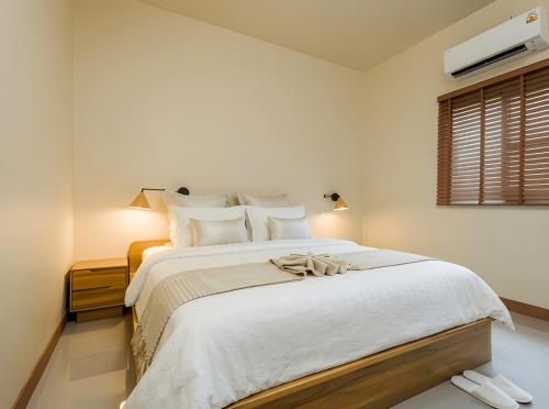 a bedroom with a large white bed with white pillows at Villa Casa Blanca in Wok Tum
