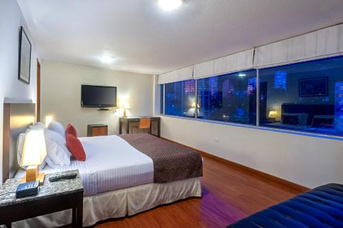 a hotel room with a bed and a large window at Hotel Oceanía Bogotá Museo in Bogotá