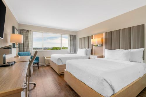 a hotel room with two beds and a desk at Best Western Dorchester Hotel in Nanaimo