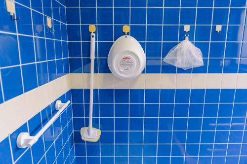 a blue tiled bathroom with a toilet in it at 温泉街近くの一棟貸し ひだまり in Kirishima