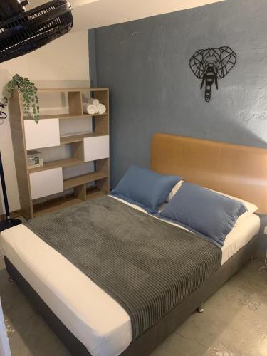 a bedroom with a bed with a headboard and a shelf at Hotel Casa Lucca in Medellín