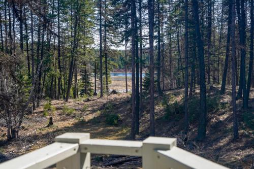 a white fence in a wooded area with a lake at Off Grid Retreat Stay for 7 in Rexford