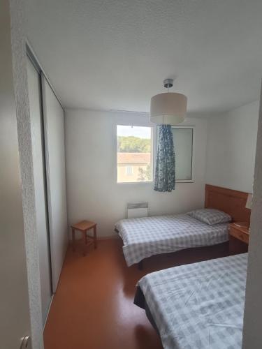 a small room with two beds and a window at Au refuge de Rolf in Calvisson