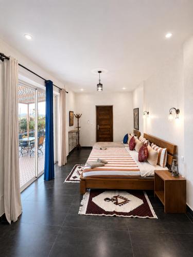 a large bedroom with a large bed and a balcony at Maison D'hôtes IMINIGRAN & Spa in Ouarzazate