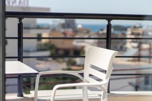 a white chair sitting on top of a balcony at D&D HOTEL Ksamil in Ksamil