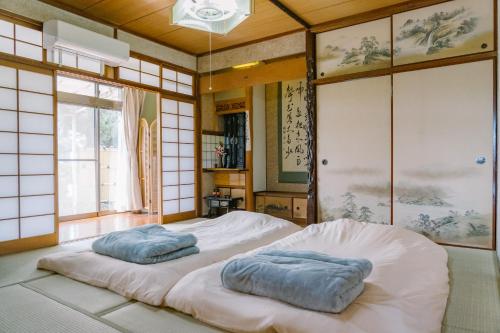 two pillows sitting on top of a bed in a room at 温泉街近くの一棟貸し ひだまり in Kirishima
