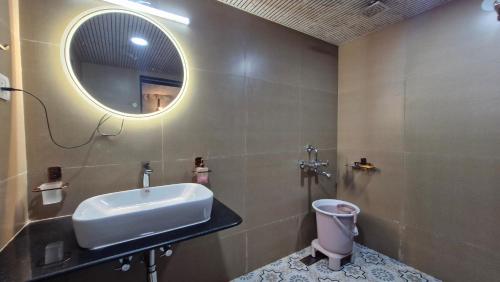 a bathroom with a sink and a mirror and a toilet at Whispering Woods in Gorthan